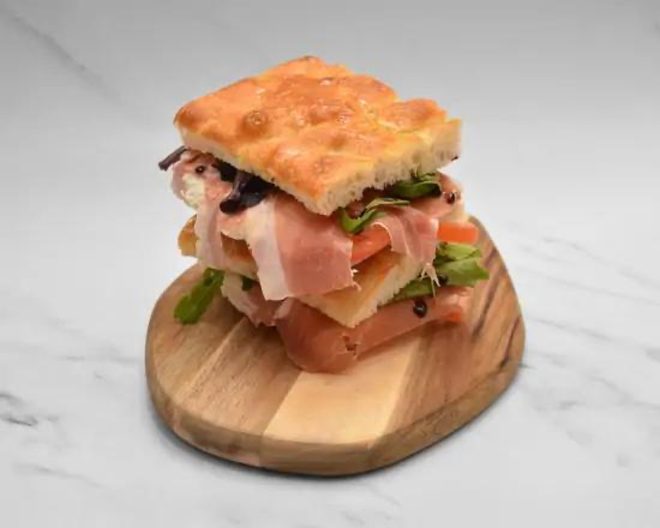 A focaccia sandwich on a round wooden board